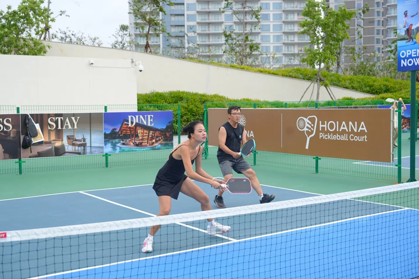 바다를 배경으로 로맨틱하게 꾸며진 베트남 리조트 웨딩 패키지 현장, 하얀 천과 꽃장식으로 장식된 야외 결혼식 세팅.