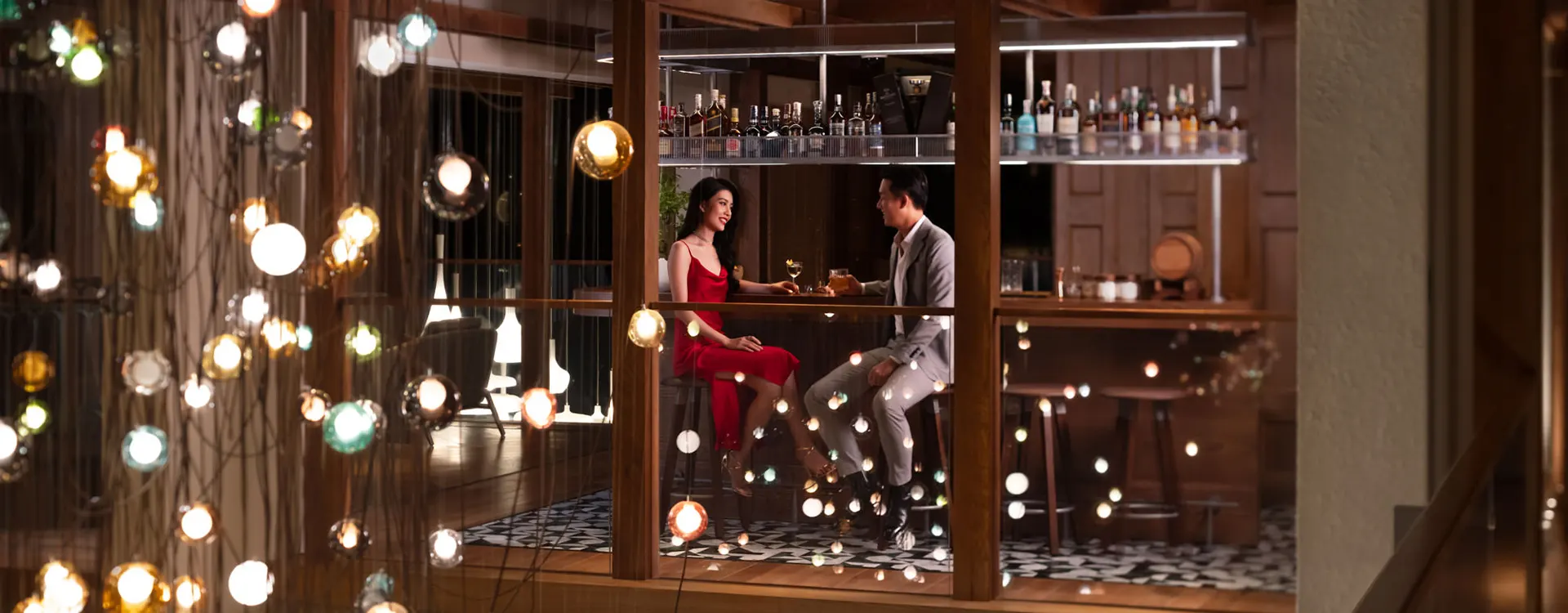 "고급스러운 분위기의 호이안 샴페인 바, 황금빛 조명 아래 샴페인 잔이 세팅된 테이블과 세련된 바 인테리어.