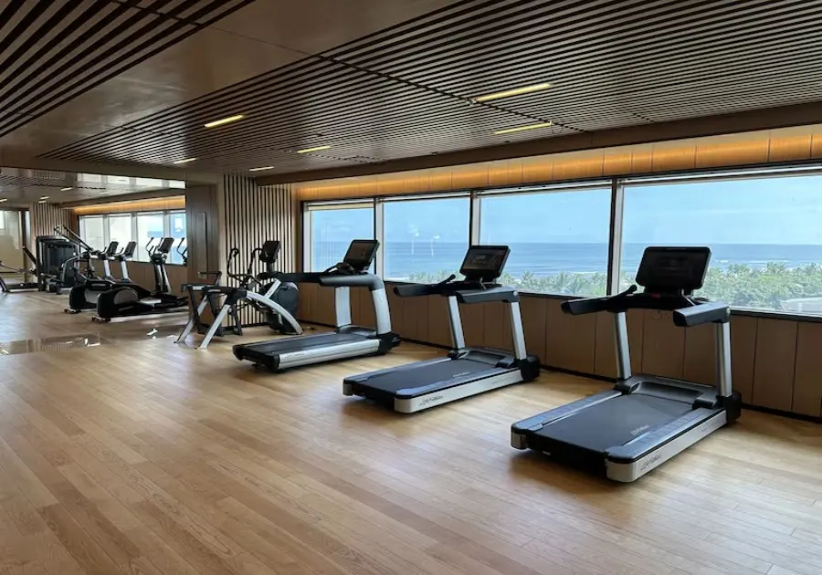 호이안 헬스클럽에서 건강한 운동을 즐기는 사람들의 모습, 최신 피트니스 장비와 넓은 공간을 갖춘 현대적인 헬스클럽 내부.